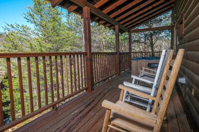 Covered side deck with Rocking chairs overlooking a wears Valley wooded view