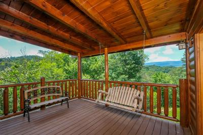 Katies Lodge main level covered back deck with swing and rocking chairs