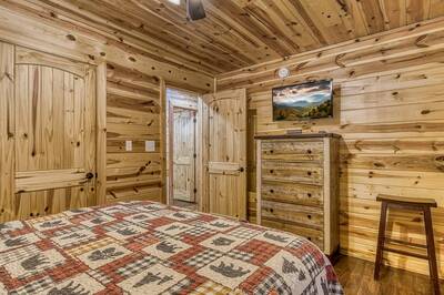 A Mountain Hideaway Lodge - Main level bedroom with queen bed and 39-inch flat screen TV