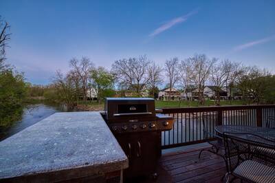 River Livin - Outdoor kitchen at night with gas grill
