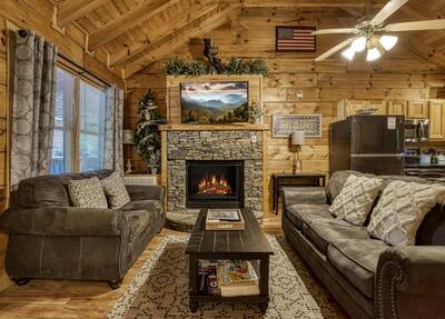 Angler's Bend living room with stone encased seasonal gas log fireplace