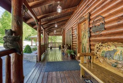 Creekside Lodge - Covered wrap around deck with a bench