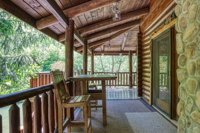 Creekside Lodge - Covered wrap around deck with table and chairs