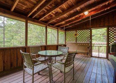 Back to Nature screened in back deck with table and chairs