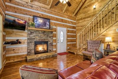 Outskirts of Heaven - Living room with seasonal stone encased gas fireplace