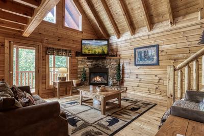 Rainbows End living room with stone encased gas fireplace