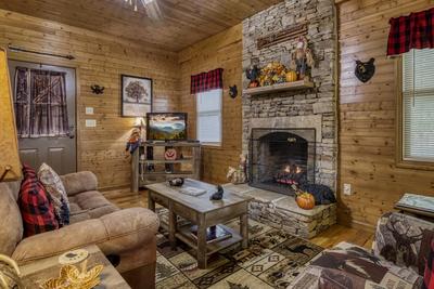 Bearfootin living room with seasonal stone encased gas fireplace