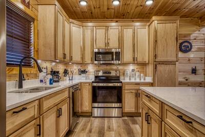 Cozy Cub Cabin fully furnished kitchen with stainless steel appliances and granite countertops