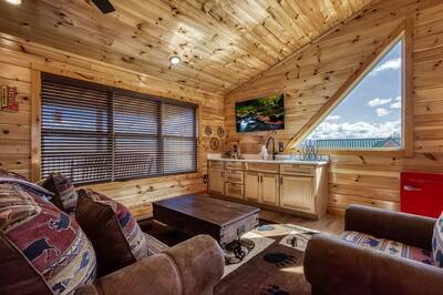 Cozy Cub Cabin upper level loft area with 55 inch TV