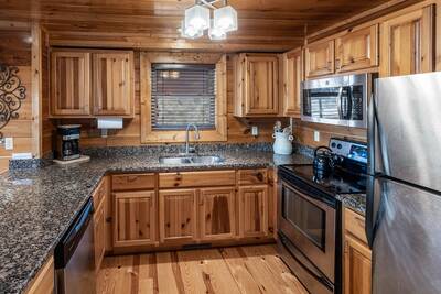 Heavenlights fully furnished kitchen with granite countertops and stainless steel appliances