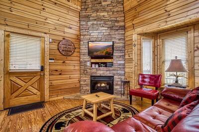 River Cabin living room with stone encased seasonal gas fireplace