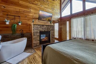 You Light Up My Life bedroom with king bed, spa soaking tub, and gas fireplace