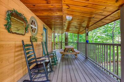 Campfire Lodge wrap around covered deck with rocking chairs and picnic table