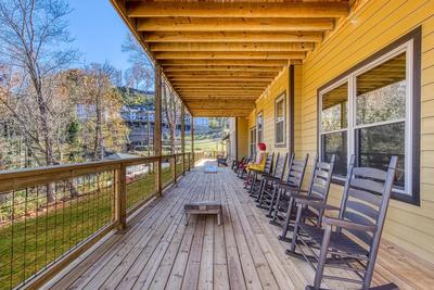 The Lodge at Burg Hill covered deck with rocking chairs and corn hole game