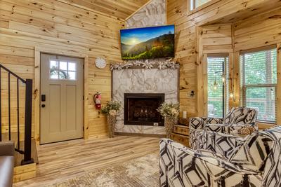 Midnight Bowling living room with seasonal tiled gas fireplace and 65 inch TV