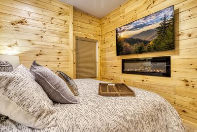 Midnight Bowling lower level bedroom with year round electric fireplace and 65 inch TV