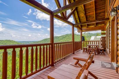 Wet and Wild main level deck with rocking chairs, picnic table, and panoramic mountain views