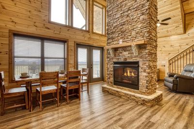 View to a Thrill dining area and double sided stone encased gas fireplace