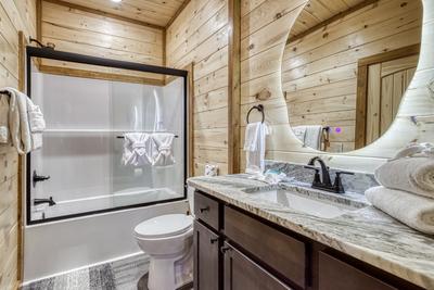View to a Thrill main level bathroom with tub/shower combo and single vanity