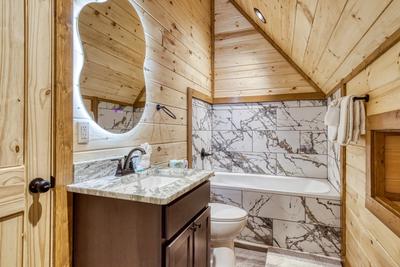 View to a Thrill upper level bathroom with spa soaking tub and single vanity