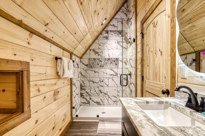 View to a Thrill upper level bathroom with single vanity and walk in shower