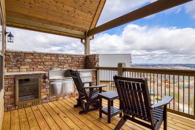 View to a Thrill main level deck with mountain views and outdoor kitchen