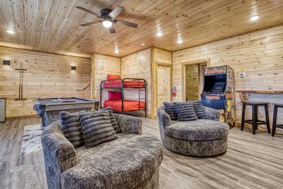 View to a Thrill lower level game room with pool table, bunk beds, and arcade game