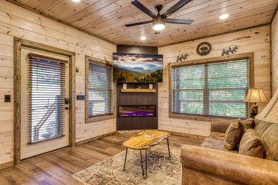 Honey Bear living room with 65 inch TV and year round electric fireplace