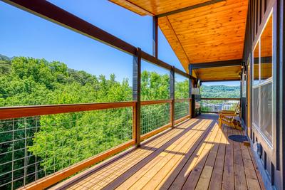 Honey Bear upper level covered wrap around deck with mountain and city views