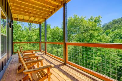 Honey Bear lower level covered wrap around deck with mountain and city views