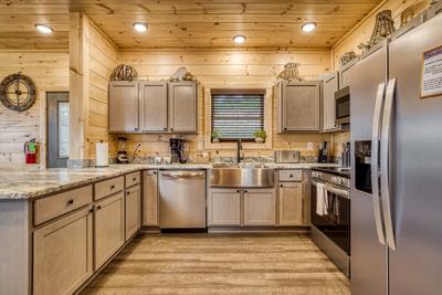 In The Clouds fully furnished kitchen with stainless steel appliances and granite countertops
