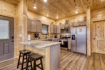 In The Clouds fully furnished kitchen with granite countertops and stainless steel appliances