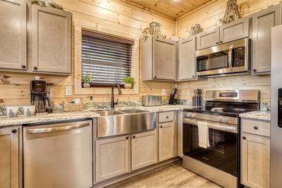 In The Clouds fully furnished kitchen with stainless steel appliances and granite countertops