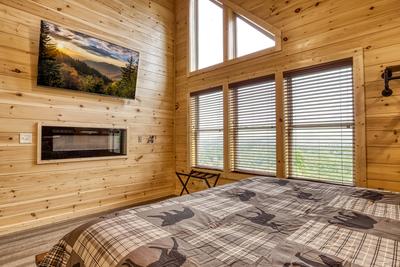 In The Clouds upper leve bedroom with king size bed, electric fireplace, and 58 inch TV