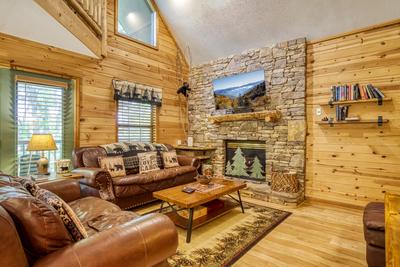 Forest Hollow living room with seasonal stone encased gas fireplace