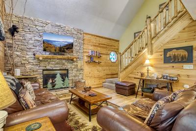 Forest Hollow seasonal stone encased gas fireplace in living room