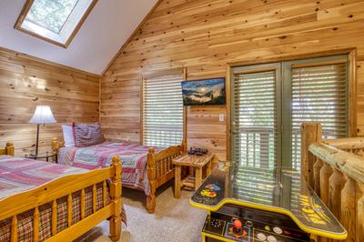 Forest Hollow upper level loft area with twin size beds and cocktail arcade game