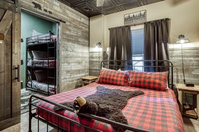 The Playful Bear lower level bedroom with king size bed and bunk beds