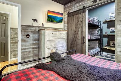 The Playful Bear lower level bedroom with king size bed and 2 sets of triple bunk beds