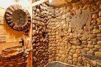 Elegant bathroom in the Wolf Room with a large rock shower and glass doors