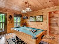 Pool table in the game room with TV and porch access