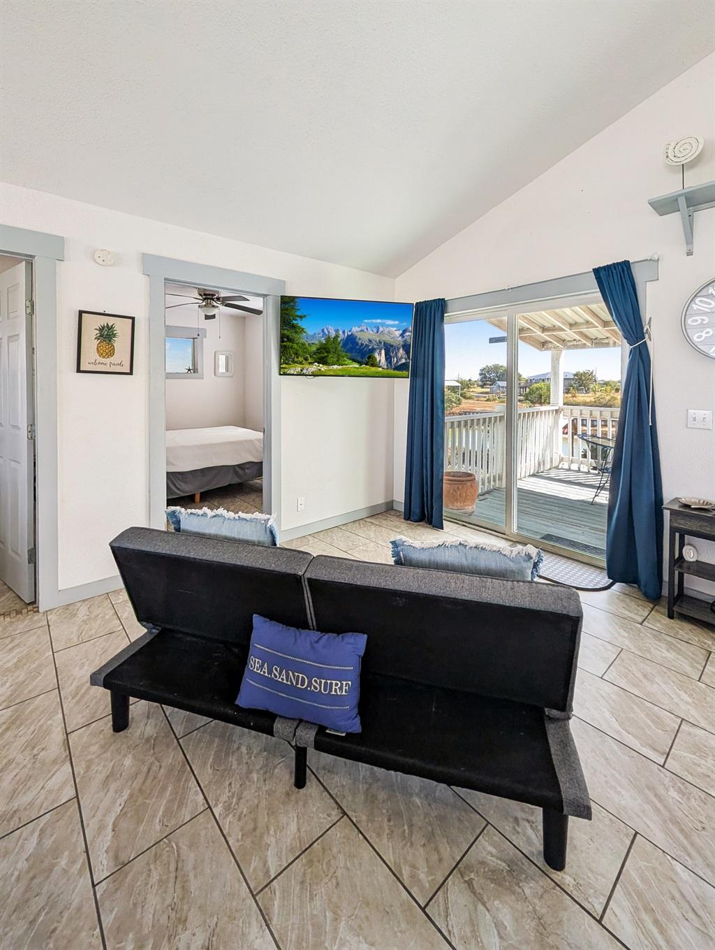 Couch, wall mounted smart tv, water views out the sliding  door