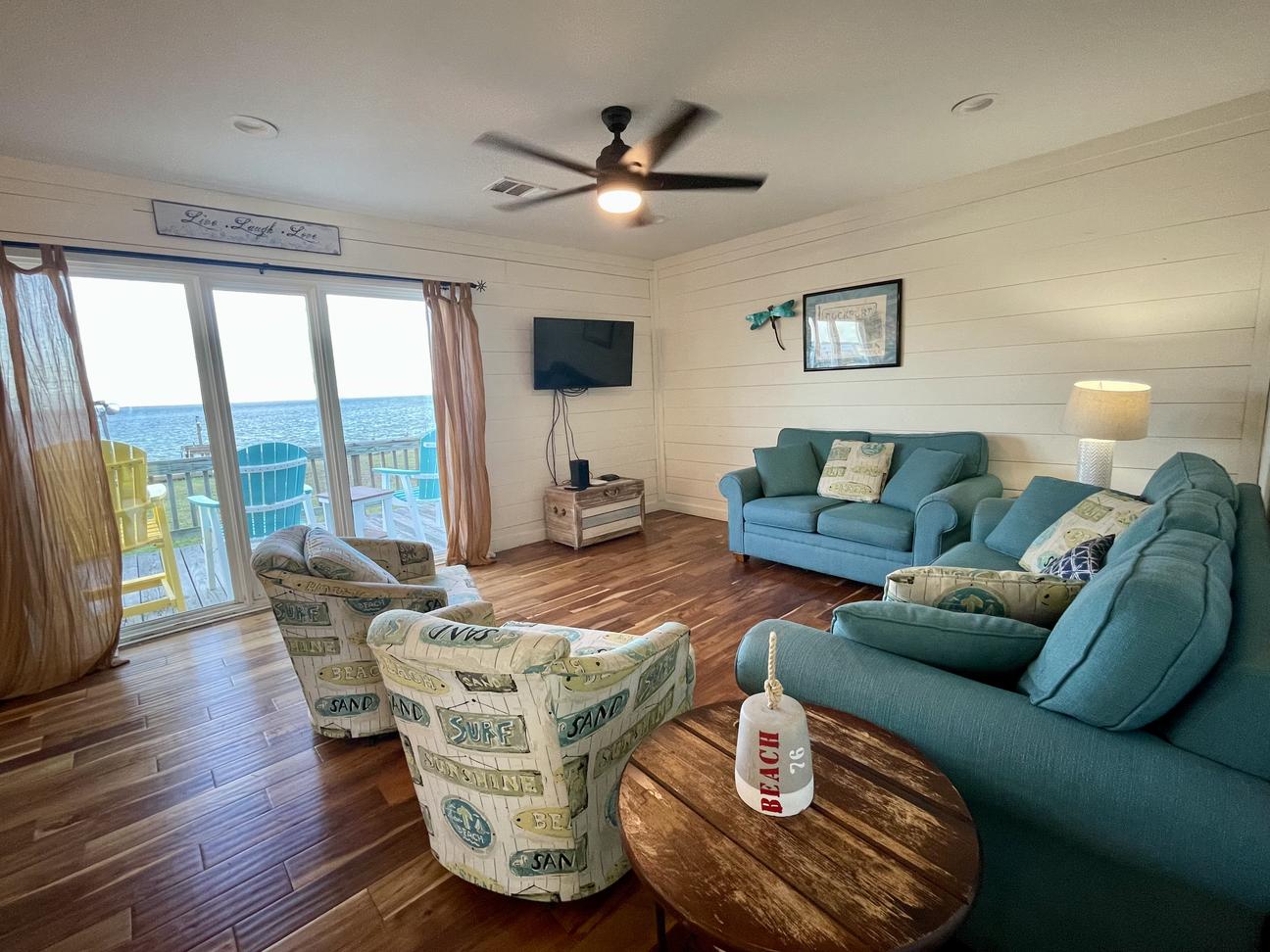 Cozy couches and chairs in the living room face large windows with bay views.