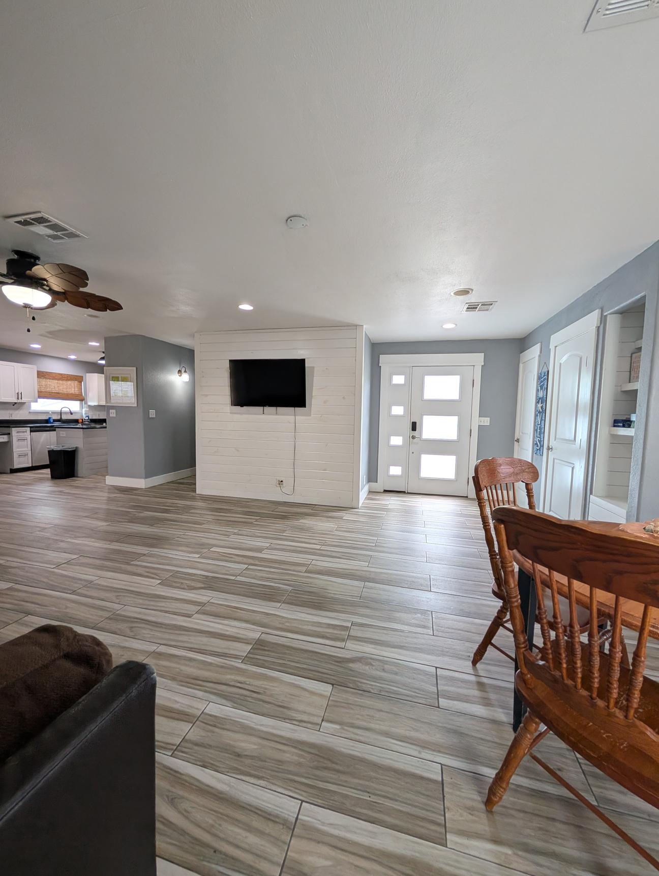 large living room with sectional couch and smart TV mounted on the wall.