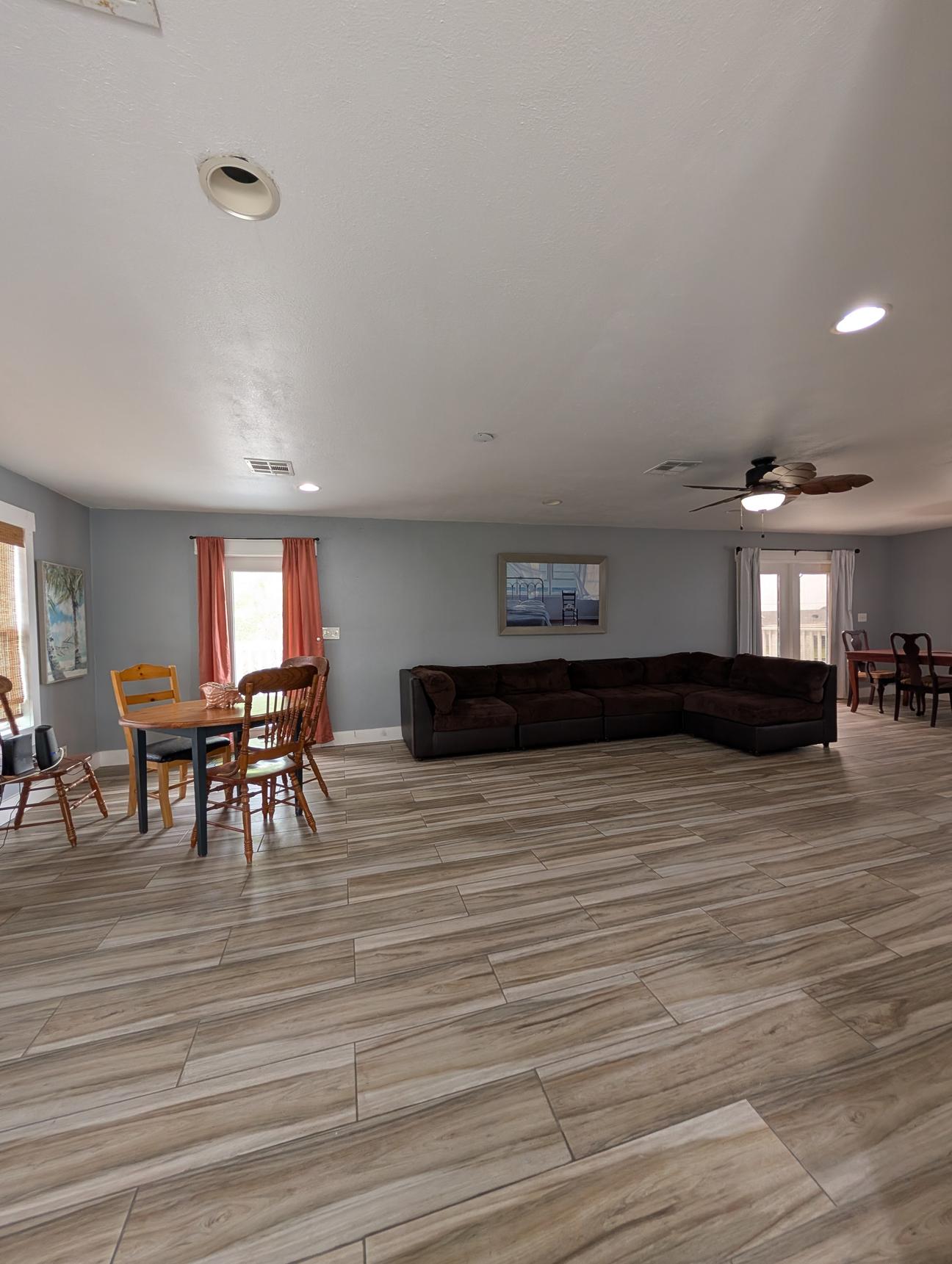 Large living room with game table and brown sectional couch