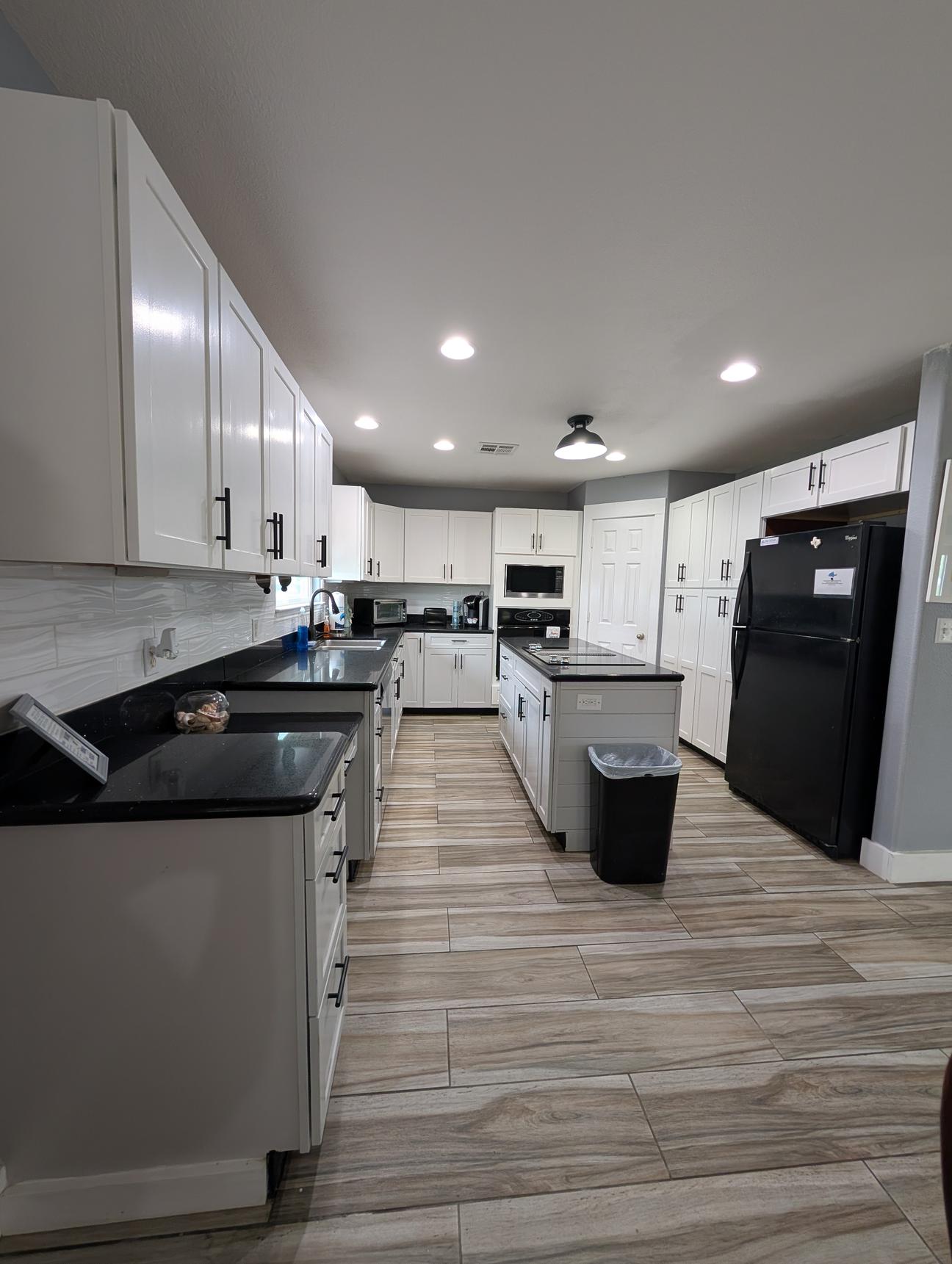black granite countertops in a modern kitchen with white cupboards. 