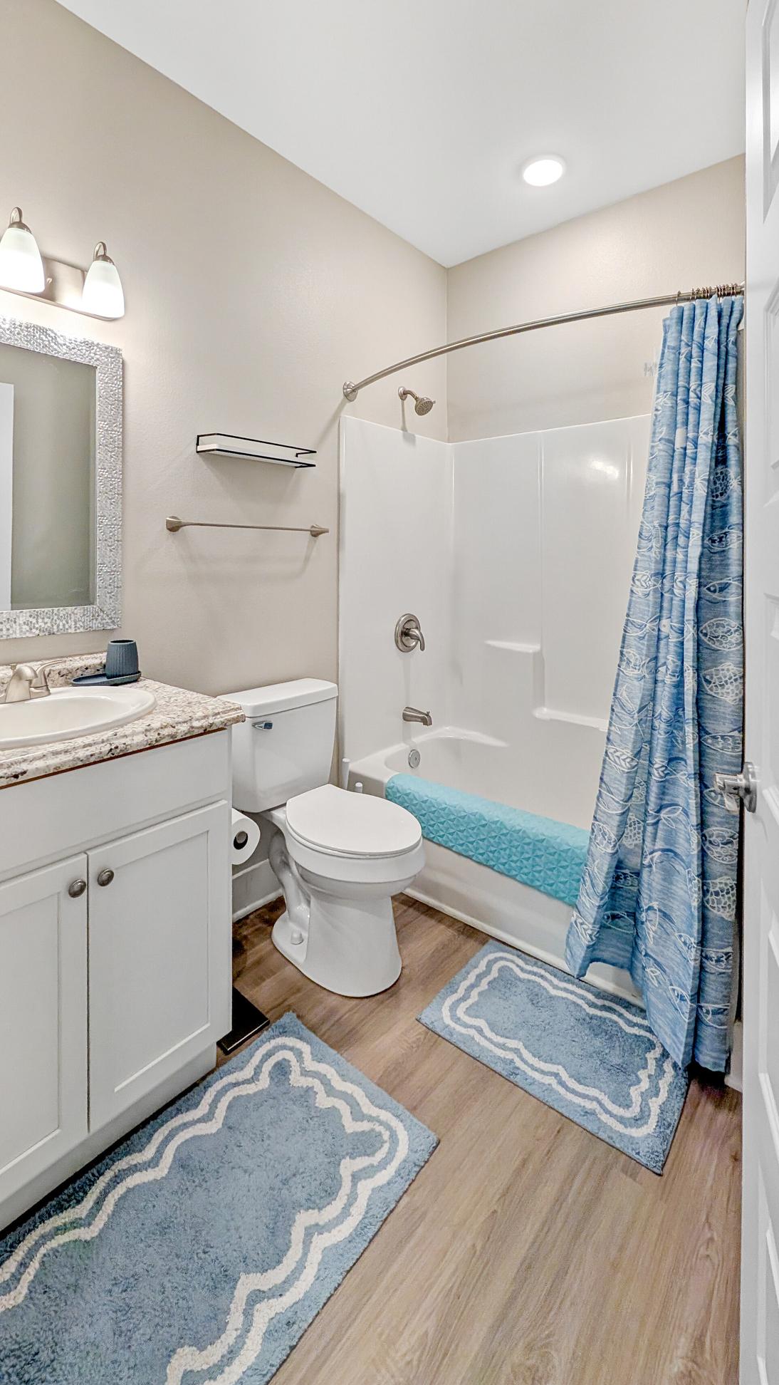 Shower tub conmbo in a bathroom decorated in coastal tones of blue and white. 