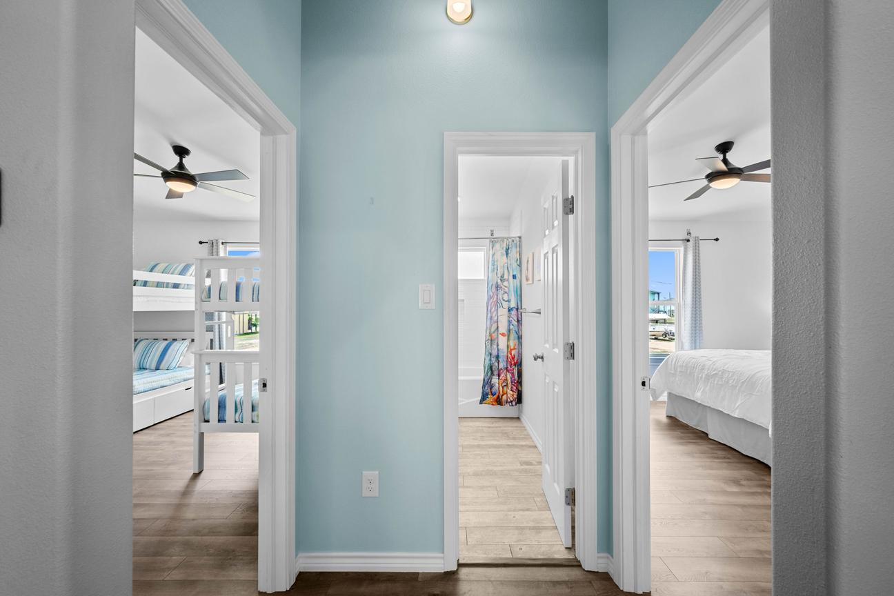 Coastal hallway connecting the bunk room, queen bedroom, and shared bathroom.