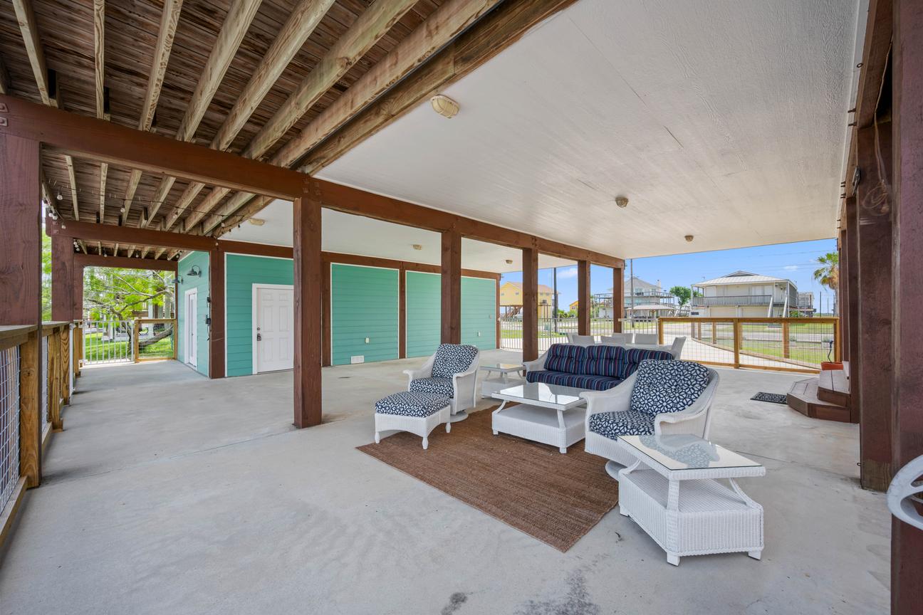 Covered outdoor patio at SeaGlass Smiles with coastal lounge seating, a sofa, chairs, and a coffee table.