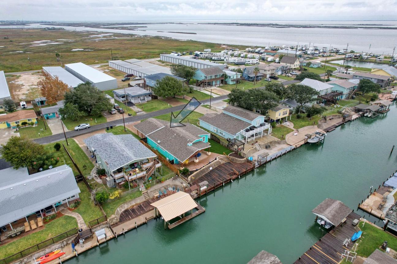 Aerial view of a canal lined with homes and docks, with an arrow marking Casa Ahoy and Estes Flats in the distance.